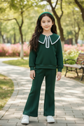 Girl with long straight hair and green headband in dark green outfit